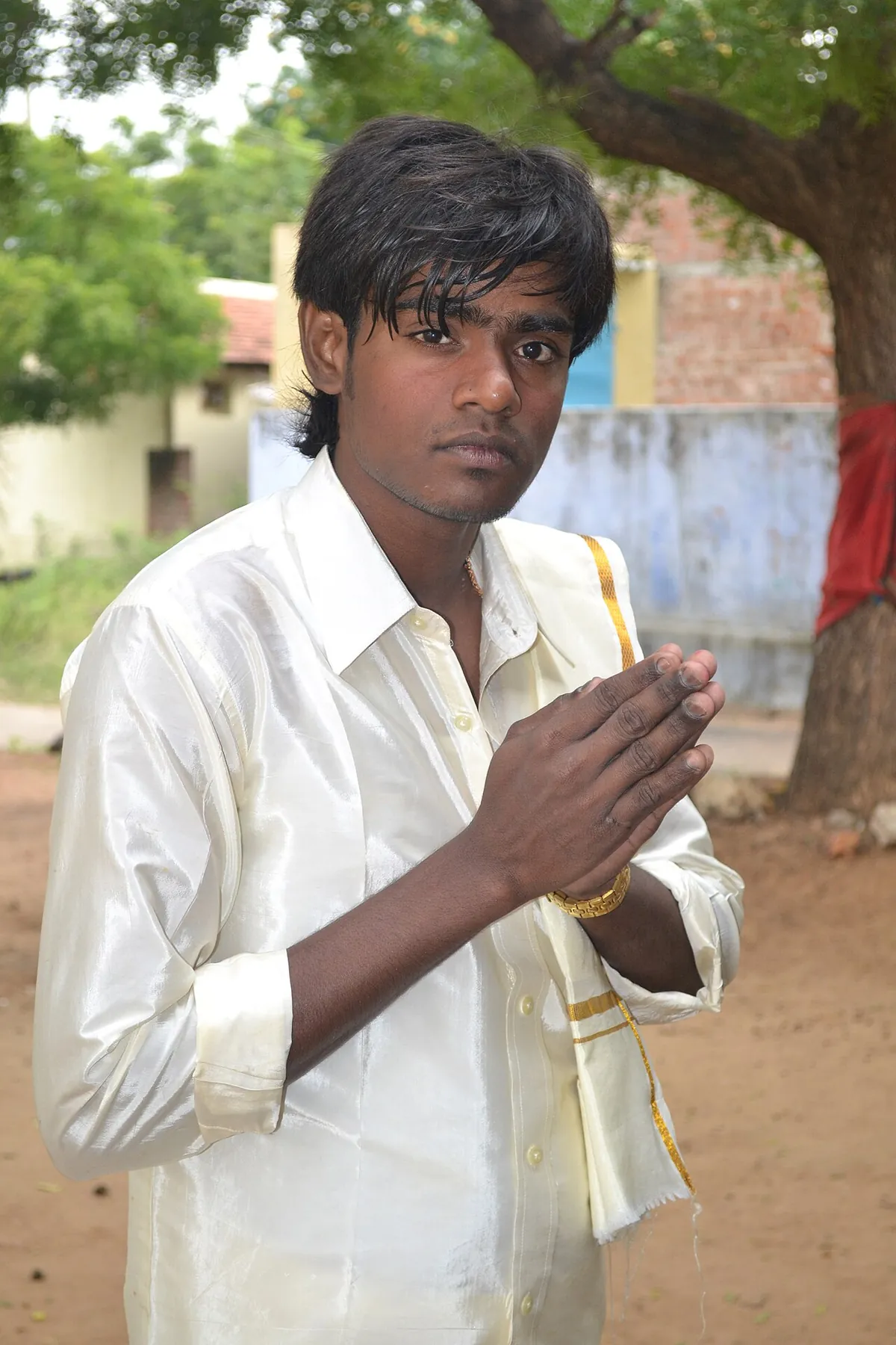 A man in India holding his palms together in front of his chest in a namaste greeting