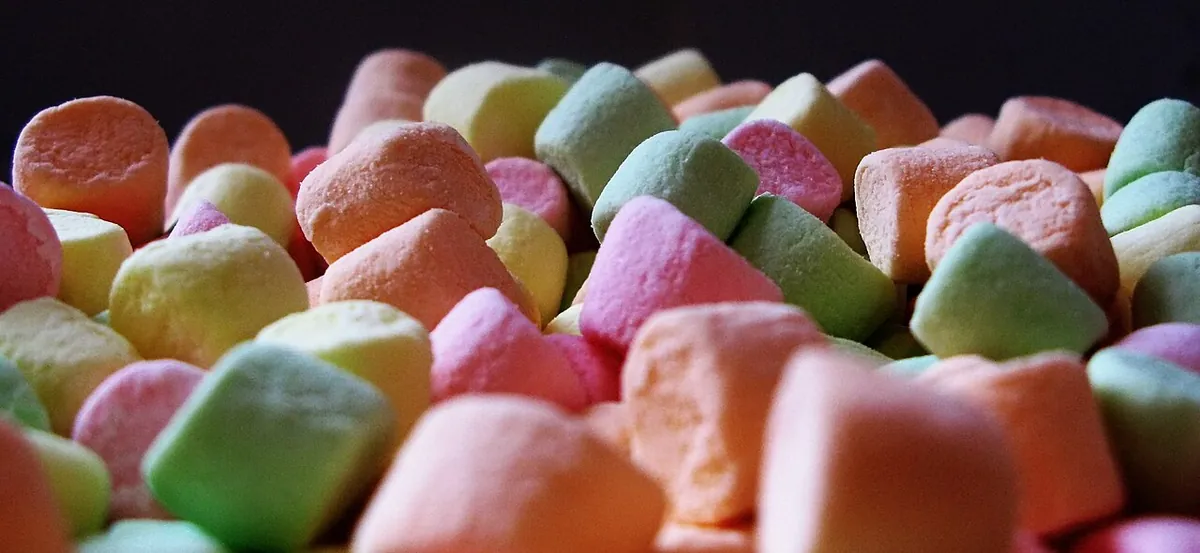 A few white marshmallows on a plate